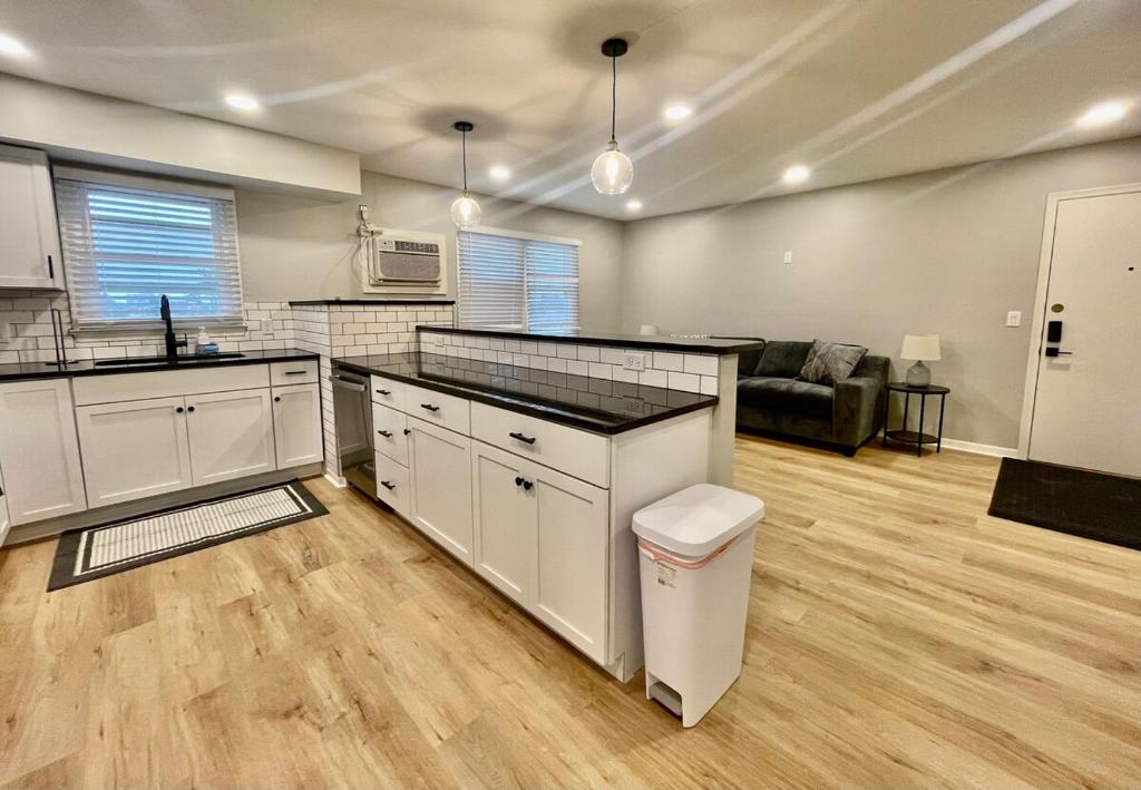 a kitchen with white cabinets and a living room at Cathedral 6-Walk to UNMC in Omaha