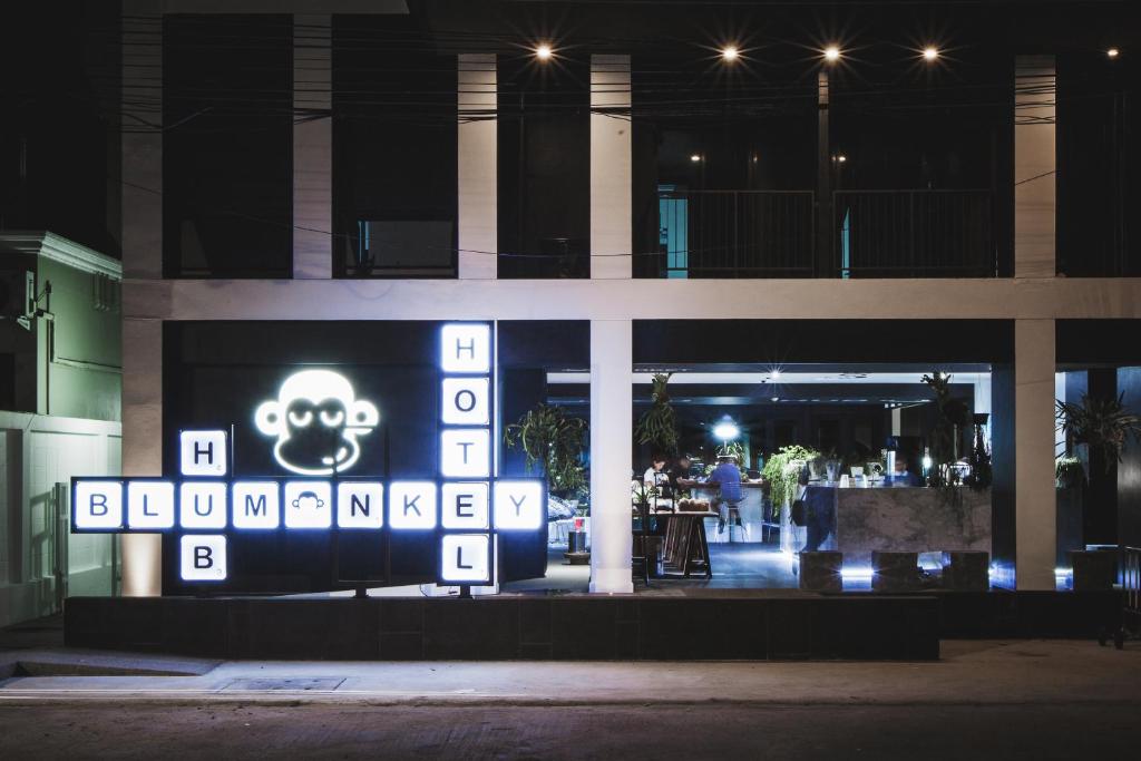 a sign in front of a building at night at Blu Monkey Hub and Hotel Phuket Town- Free All Day Coworking space in Phuket Town