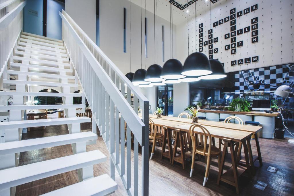 a staircase leading up to a restaurant with tables and chairs at Blu Monkey Hub and Hotel Phuket Town- Free All Day Coworking space in Phuket Town