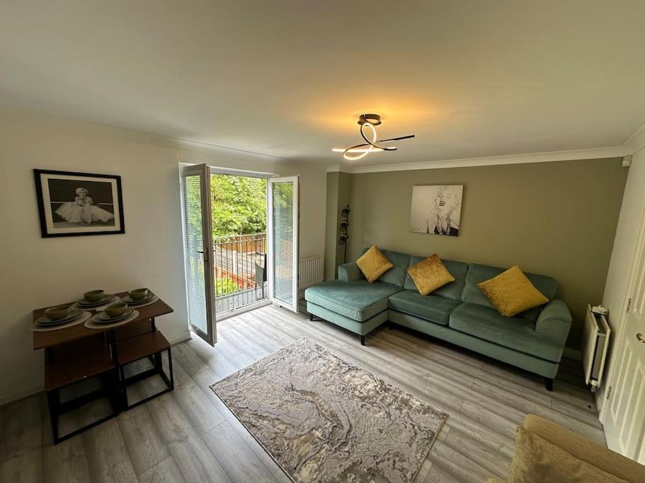 sala de estar con sofá verde y mesa en Mmc serviced accommodation 2, en Leigh