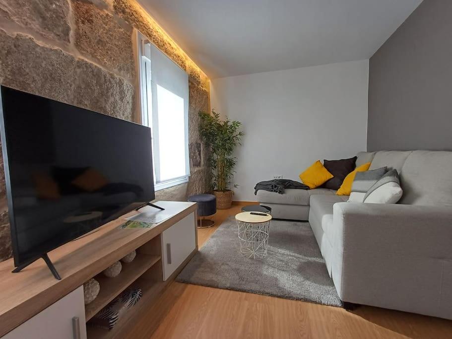 a living room with a couch and a large flat screen tv at Descansa y disfruta de Ourense en Villa Fayma in Ourense