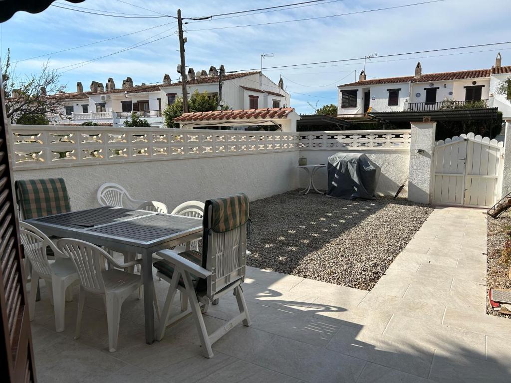 eine Terrasse mit einem Tisch, Stühlen und einem Zaun in der Unterkunft Adosado cerca de la playa in Torredembarra