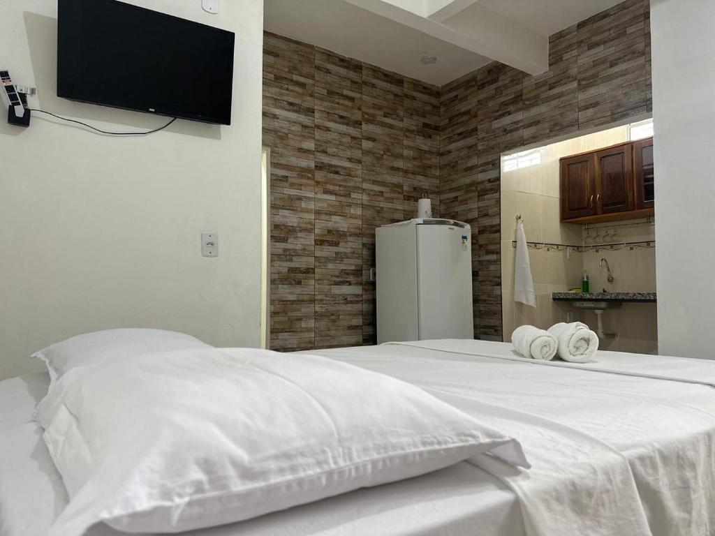ein Schlafzimmer mit einem weißen Bett mit Handtüchern darauf in der Unterkunft Studio Executivo no Centro de Santarém - WIFI e Central de Ar in Santarém