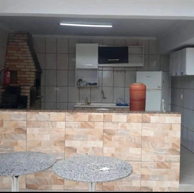 una cocina con 2 mesas frente a un mostrador en Pousada Canto Feliz, en Peruíbe