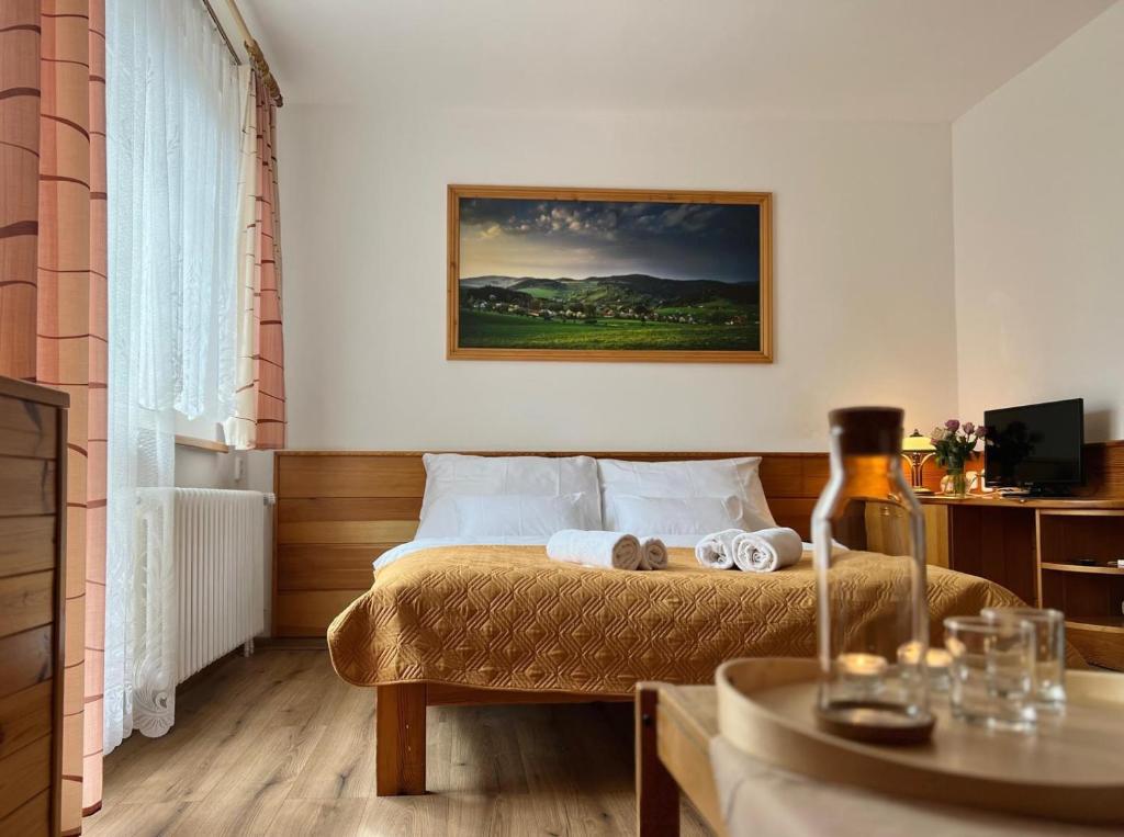 a bedroom with a bed with towels on it at Hotel Horník in Vlachovice