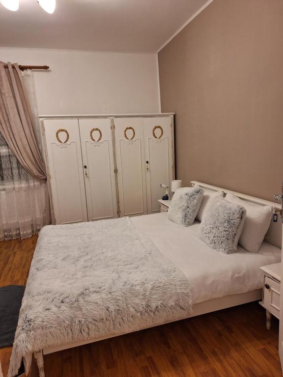 een slaapkamer met een groot wit bed met 2 kussens bij Parc Apart Vatra Dornei in Vatra Dornei