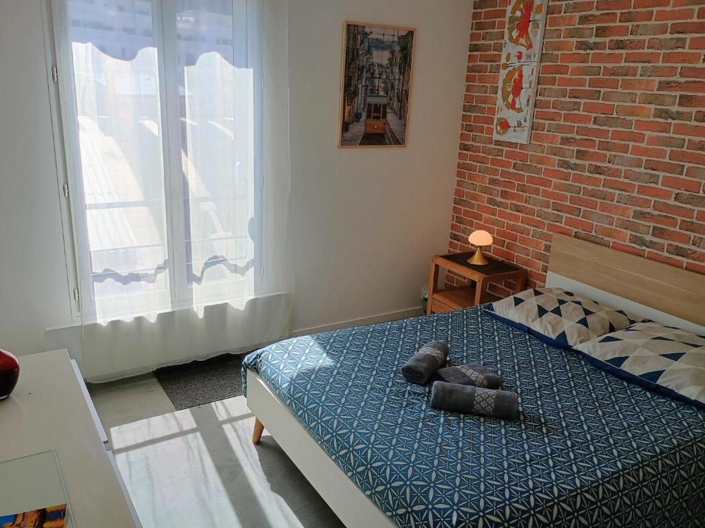 a bedroom with a bed and a brick wall at Proche Paris,Cosy appartement, 3 bedrooms in Saint-Ouen