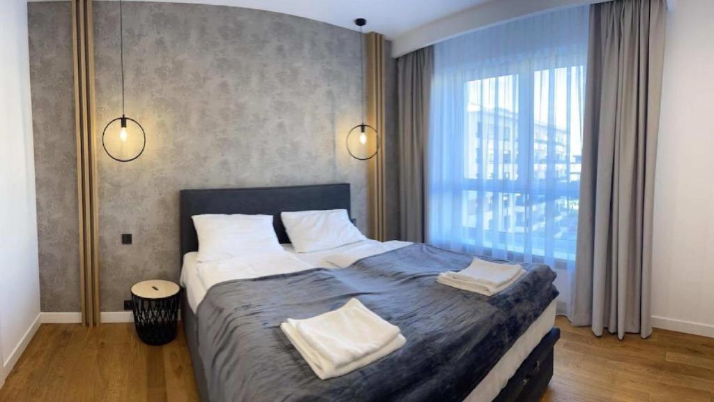 a bedroom with a large bed with two pillows at Apartaments Airport Komputerowa Premium in Warsaw