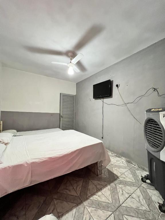 a bedroom with a bed and a flat screen tv at Pousada Sol in Goiânia