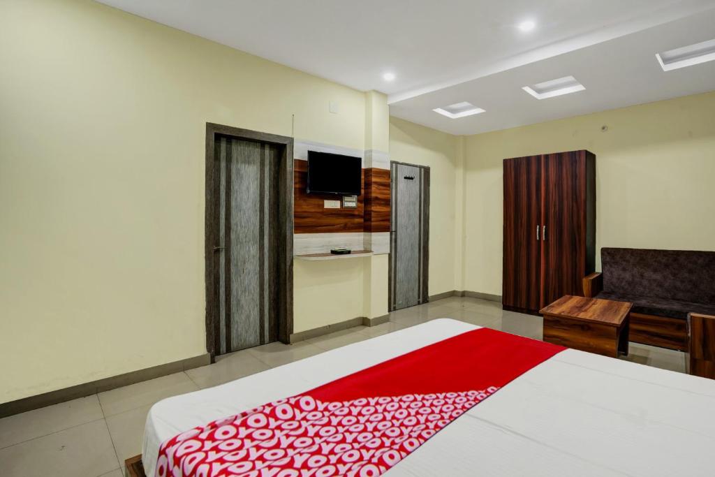 a bedroom with a bed and a desk and a television at OYO Hotel Shubham in Rānchī