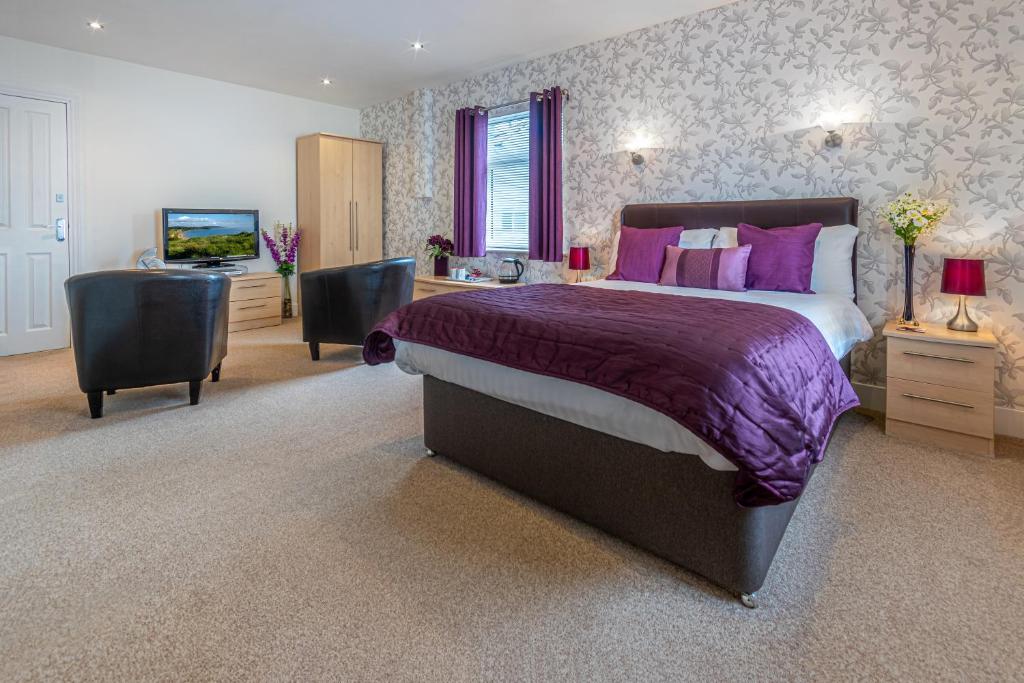 um quarto com uma cama grande e uma televisão em The Richmond Bed and Breakfast - Adults only em Shanklin