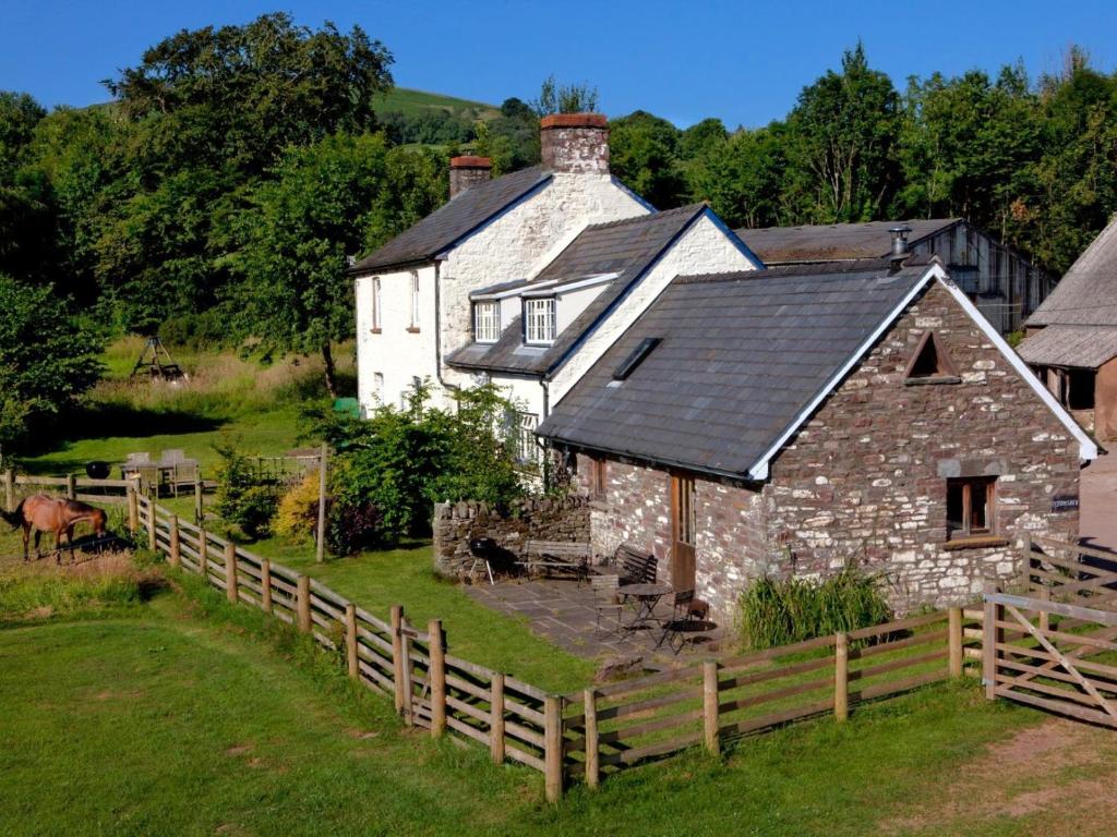 an old stone house with a fence in front of it at 1 bed in Cantref BN264 in Brecon