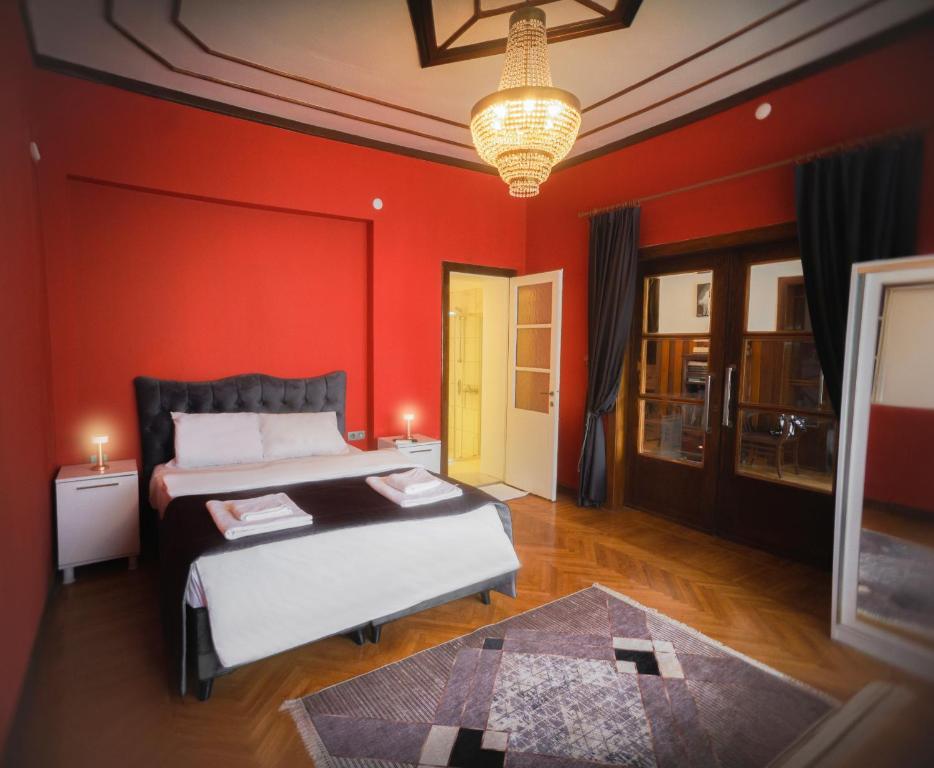 a bedroom with a bed and a red wall at Hotel Renk Palace in Buyukada