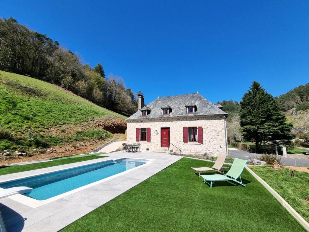 - une vue extérieure sur une maison avec une piscine dans l'établissement Gîte de France Le grand air du paradis 3 épis - Gîte de France 9 personnes 464, à Argentat