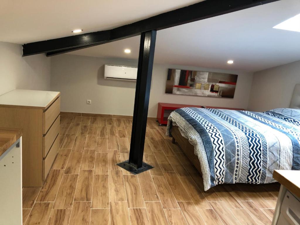 1 dormitorio con 1 cama y suelo de madera en Habitación con cocina y baño, en Bilbao