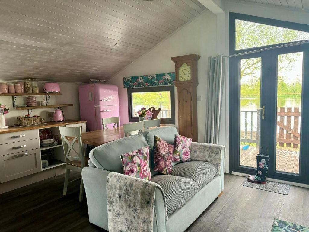 a living room with a couch and a table at Stunning 2 Bed Lodge On The Lake in South Cerney