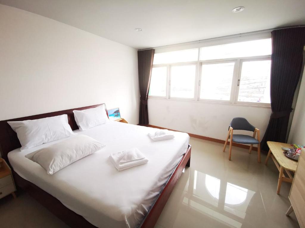 a bedroom with a bed with white sheets and a window at Proud Room &wifi 2 in Pattaya North