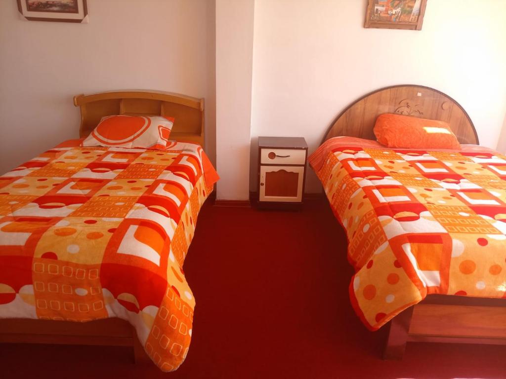 two beds sitting next to each other in a bedroom at INKA'S DREAMS HOUSE in Puno
