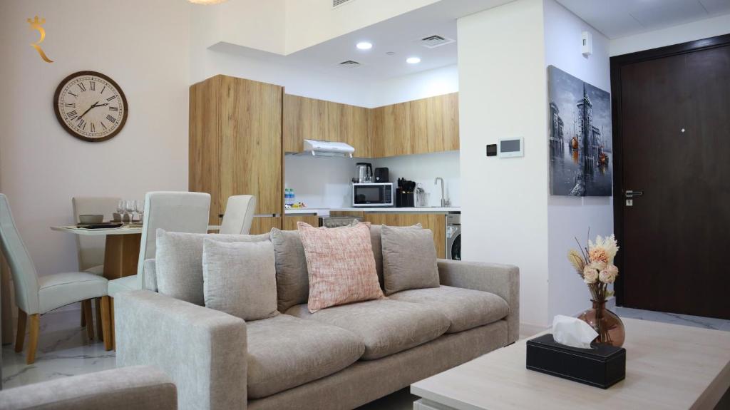 a living room with a couch and a kitchen at Skyline Azure - Elegant 2BR Duplex in Oasis Near Masdar Park in Abu Dhabi