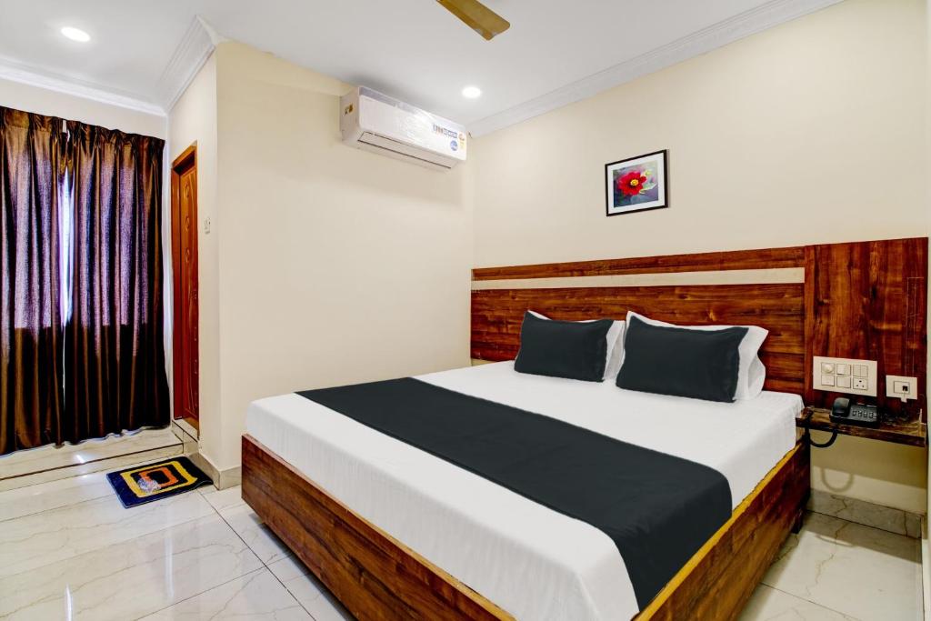 um quarto com uma cama grande num quarto em OYO Hotel Leela Elite em Vijayawada