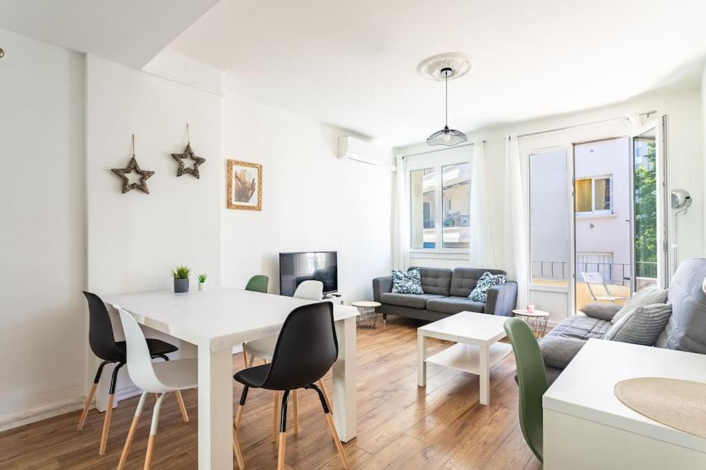 un salon avec une table et des chaises blanches dans l'établissement Appartement familial, lumineux, à Toulon