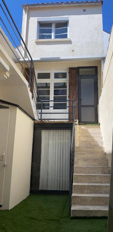une maison avec un escalier menant à une porte dans l'établissement Maison à 10 m de la mer hyper centre, à Les Sables-dʼOlonne