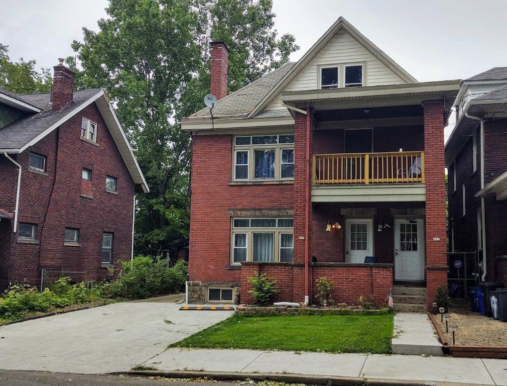 een stenen huis met een veranda en een balkon bij Boulevard Park Apartments in Erie