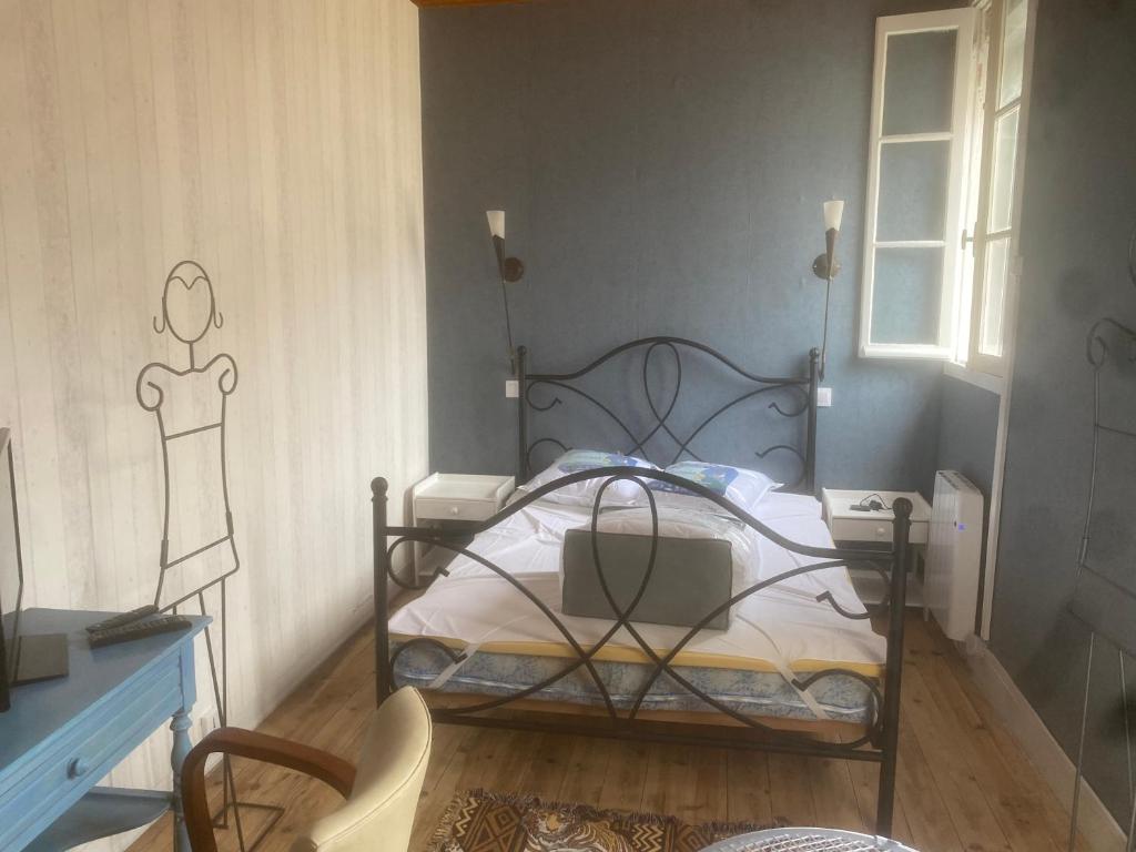 a bedroom with a bed with a wrought iron frame at Maison à 10 m de la mer hyper centre in Les Sables-d'Olonne