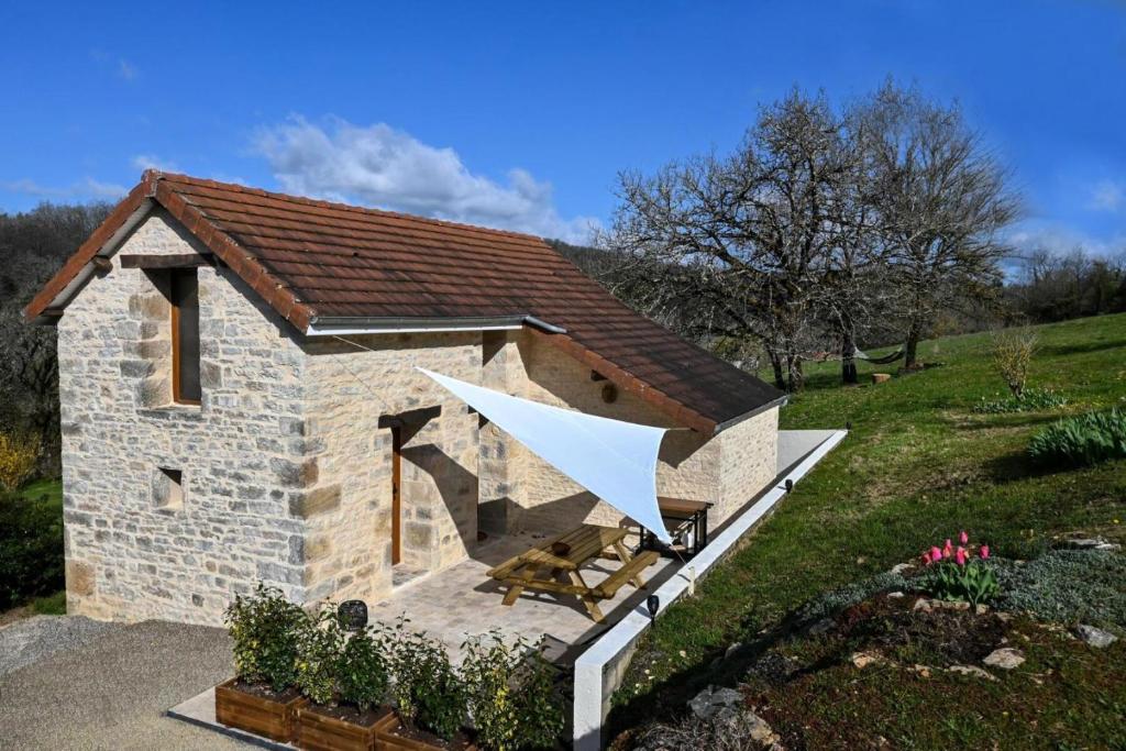 a small stone building with a white roof at Gîte de France L'écrin de lacoste 3 épis - Gîte de France 4 personnes 511 in Chasteaux