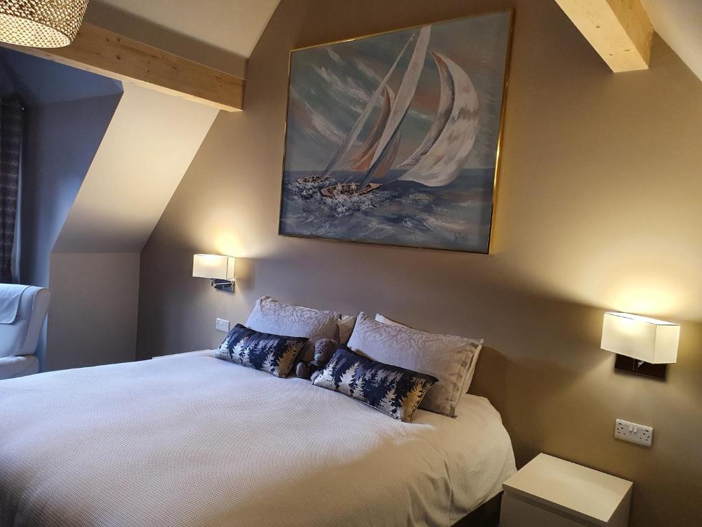 a bedroom with a bed with a painting on the wall at Maple Cottage B&B in Gullane