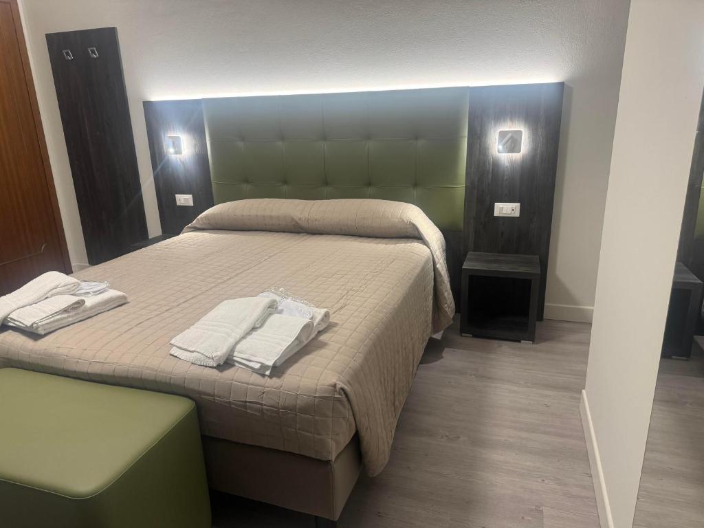 um quarto com uma cama com duas toalhas em Da Noi Trattoria Hotel em Vergato