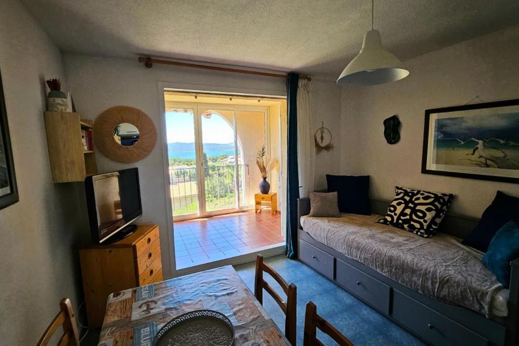 - un salon avec un canapé, une table et une fenêtre dans l'établissement Beautiful house with pool and sea view, à Saint-Mandrier-sur-Mer