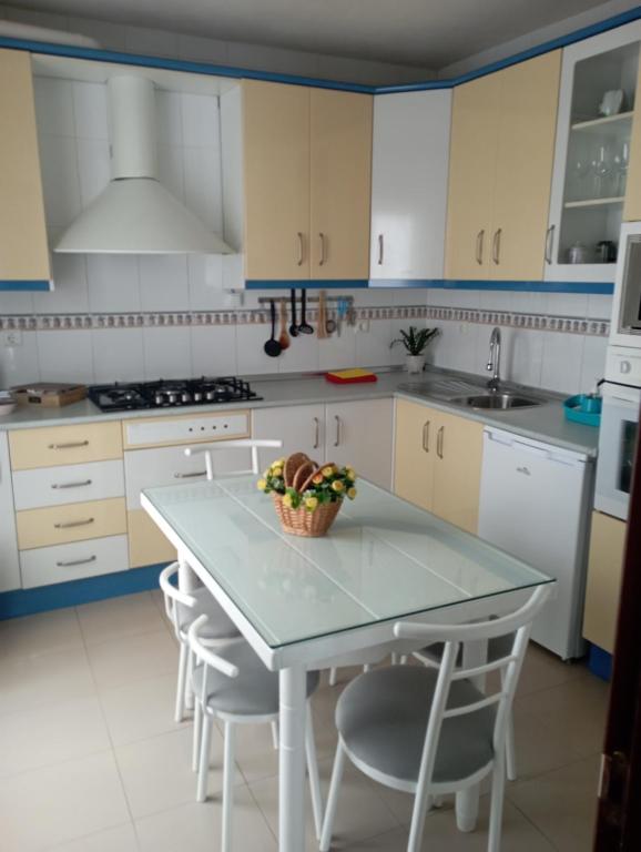 una cucina bianca con tavolo e sedie di CASA TEO a Cazorla
