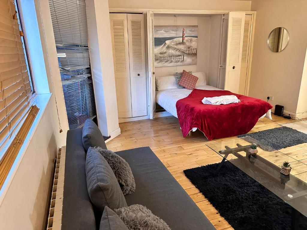ein Wohnzimmer mit einem Bett und einem Sofa in der Unterkunft Chelsea Studio Apartment - Sleeps 4 - near Cromwell Hospital in London