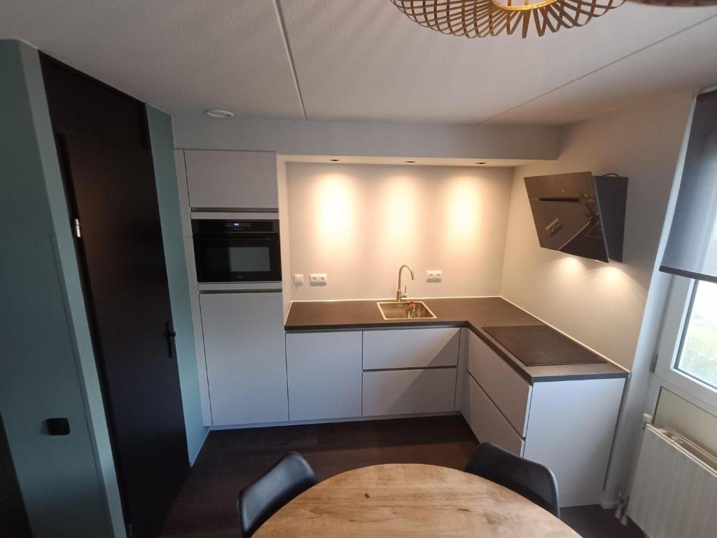 a small kitchen with a sink and a table at Prachtige vakantievilla aan IJsselmeer Makkum in Makkum