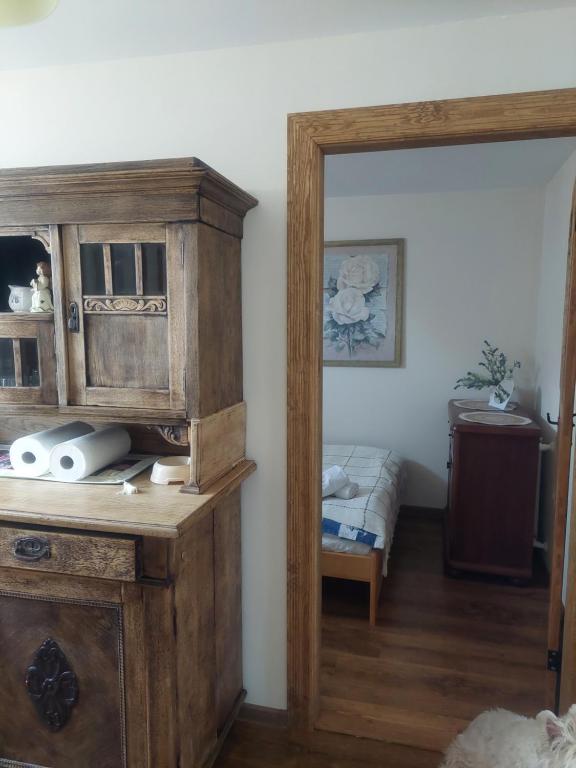 a wooden cabinet in a room with a bed at Nadmorskie Apartamenty in Ustka