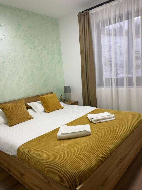 a bedroom with a large bed with towels on it at Cabana Stânceni in Drăgoiasa