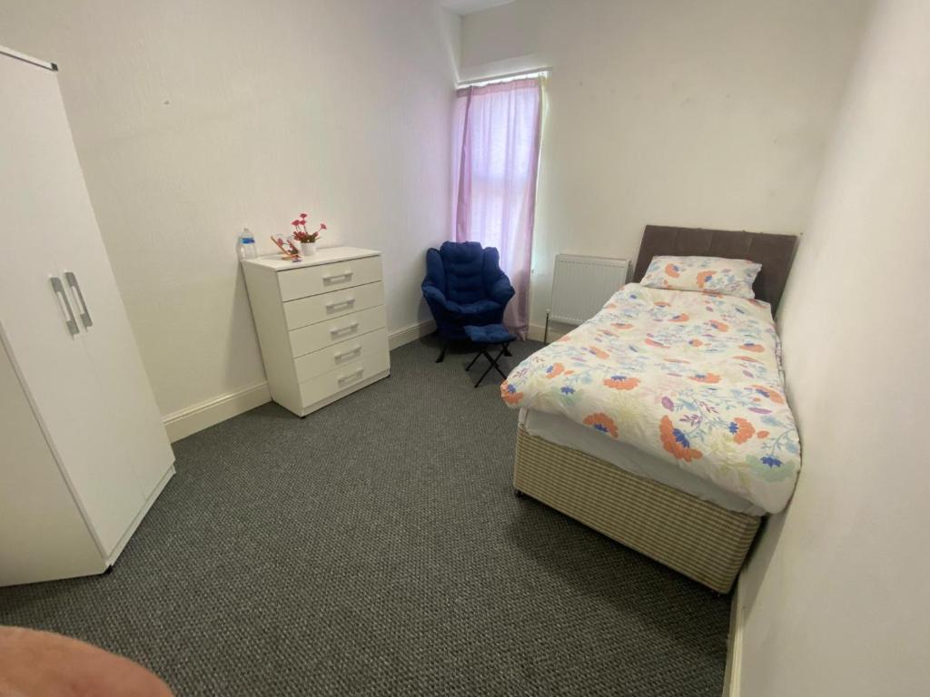 a bedroom with a bed and a dresser and a chair at Single Room in Erdington B23 in Birmingham