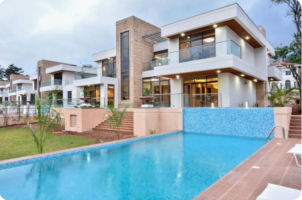 a house with a swimming pool in front of a house at Palm House in Nairobi
