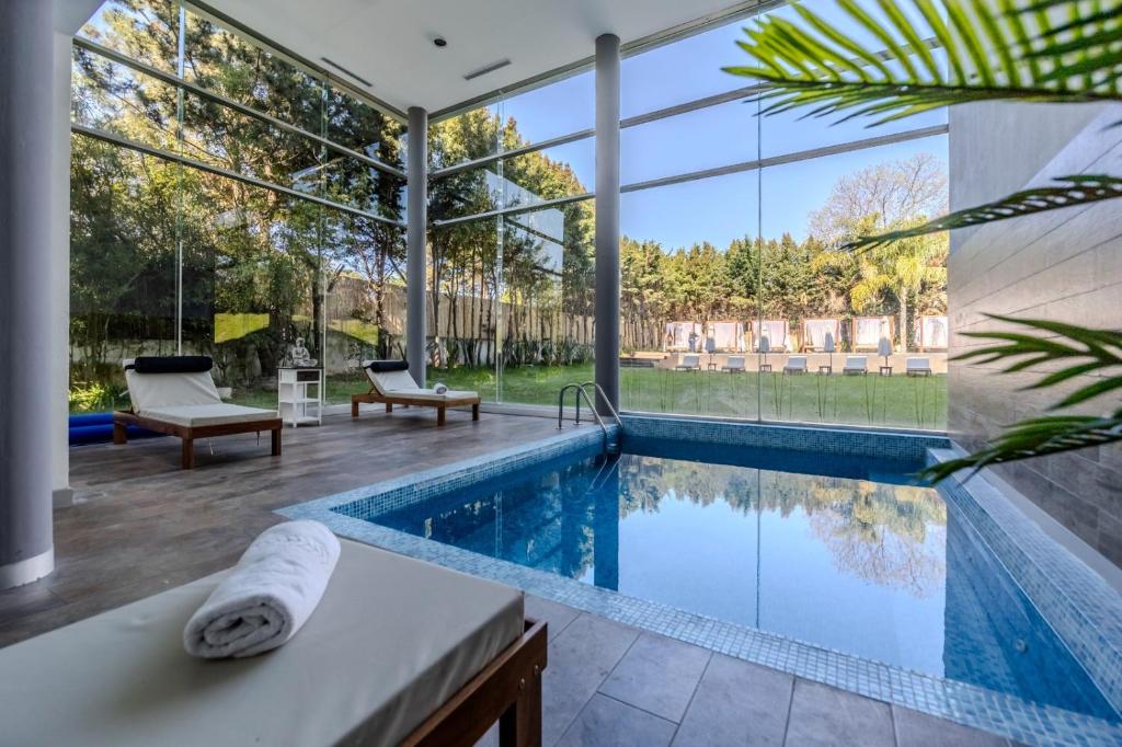 a swimming pool in a house with a large window at Park Hotel in Punta del Este