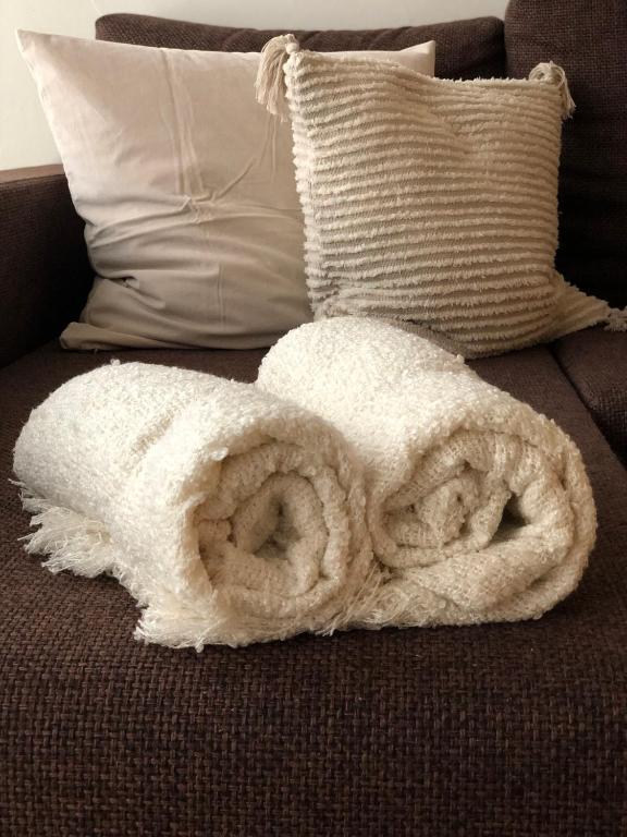 a white blanket on a couch with pillows at Ring Stop Holiday Apartment 11 in Sigulda