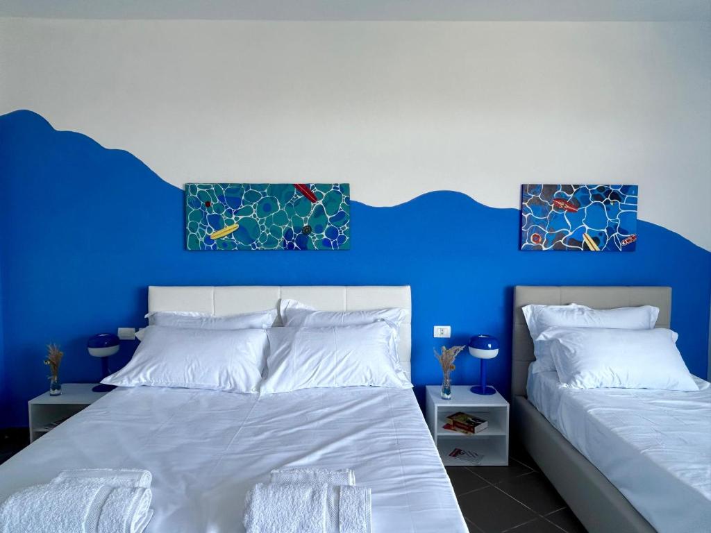 a bedroom with two beds with blue walls at Gibel Apartments in Golem