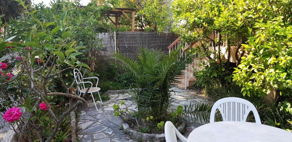 d'une terrasse avec une table et des chaises dans le jardin. dans l'établissement Résidence Bagatelle - Budget Appart proche mer entre amis et en famille MAE-7784, à Six-Fours-les-Plages