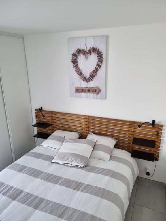 une chambre avec un lit avec une image de cœur dans l'établissement Charmante maison entre mer et forêt, à Saint-Jean-de-Monts