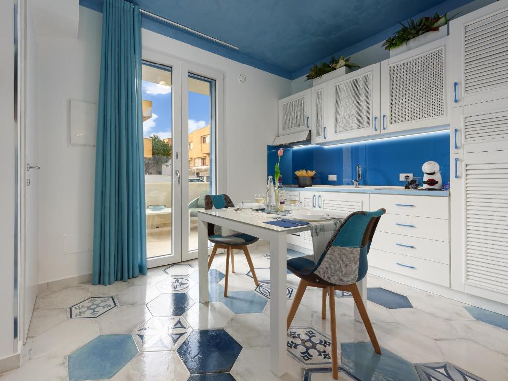 a kitchen with a white table and two chairs at IL FARO E LA LUNA Beach Apartments in San Vito lo Capo