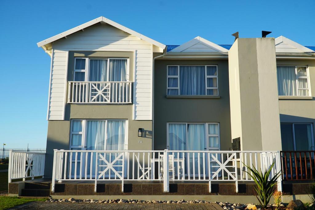 a house with a white fence in front of it at Pinnacle Point Golf Estate Lodge 78 in Mossel Bay