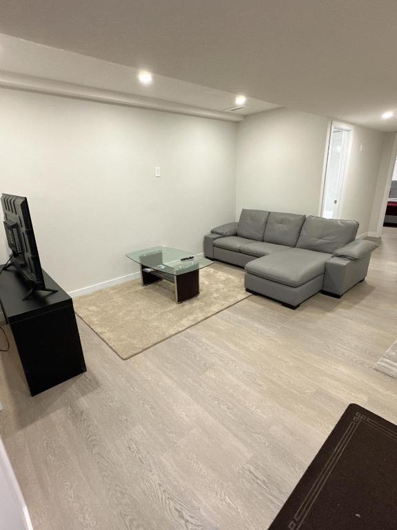 sala de estar con sofá y TV en Open modern concept 2BR basement, en Calgary