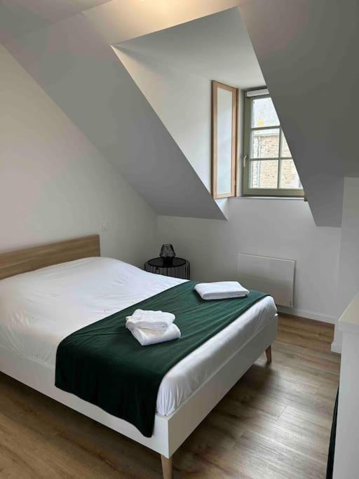 - une chambre avec un lit doté d'une couverture verte et d'une fenêtre dans l'établissement Studio au centre de Quintin, à Quintin