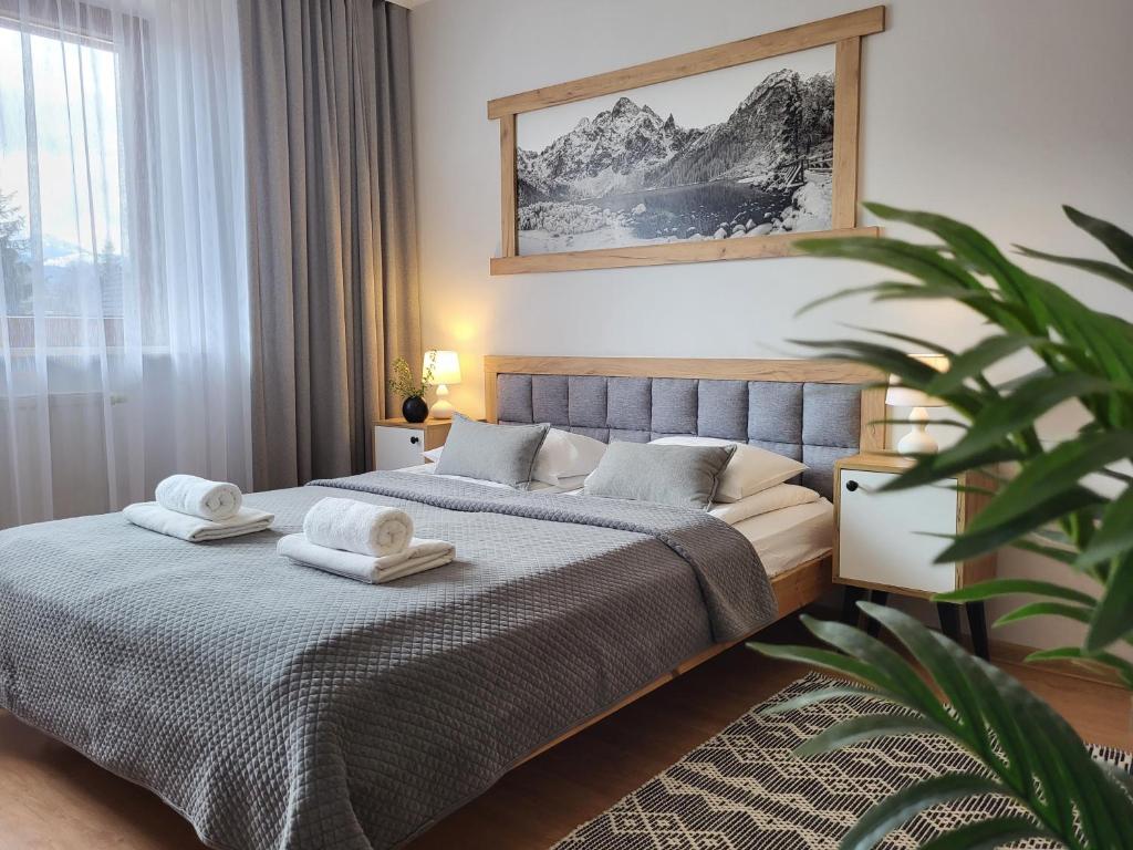 - une chambre avec 2 lits et des serviettes dans l'établissement Apartamenty Velvet, à Kościelisko