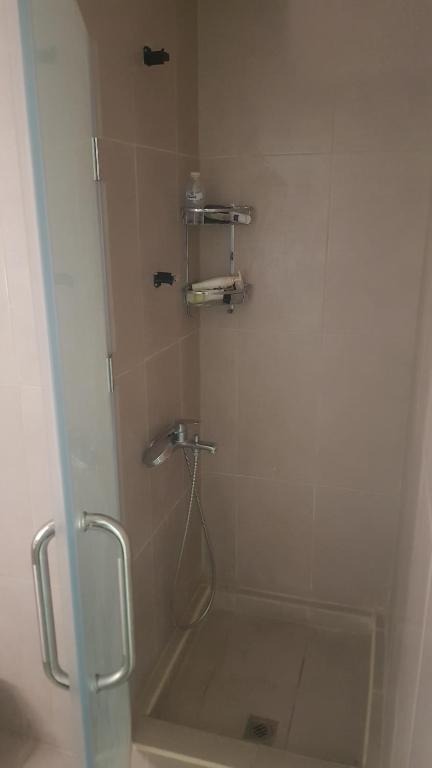 a bathroom with a shower with a tub and a sink at M apartment in Kuwait
